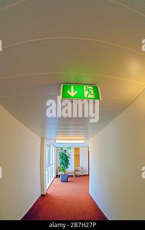 escape route in a hotel, marked by overhead fixed illuminated signs Stock Photo