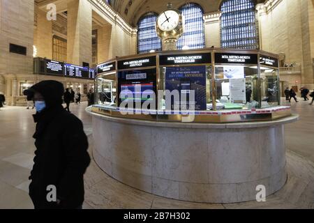 New York, United States. 16th Mar, 2020. A man wearing a face mask stands in a near empty Grand Central Station Terminal between 7:30 and 8 AM to start the week in New York City on Monday, March 16, 2020. Over a million New York City public school children are staying home Monday with the first day of closure of public schools in New York City. New York Mayor Bill De blas is also signing an executive order Monday limiting restaurants to take-out only and shutting down bars and clubs that do not serve food. Photo by John Angelillo/UPI Credit: UPI/Alamy Live News Stock Photo