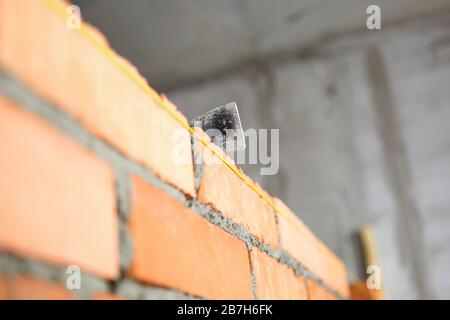 Mallet lying on top of brick wall as building and renovation Stock Photo