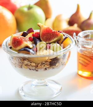Breakfast healthy concept. Yoghurt, muesli and fresh fruits in a bowl, blur background. Closeup view of food for a healthy lifestyle. Stock Photo