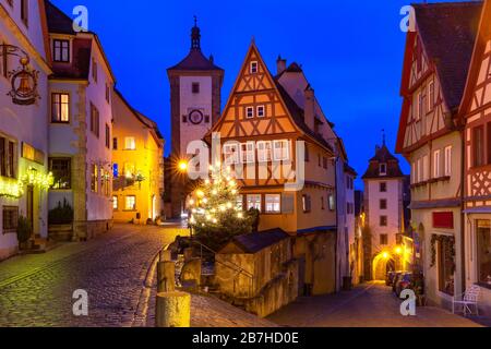 Decorated and illuminated Christmas street with gate and tower Plonlein in medieval Old Town of Rothenburg ob der Tauber, Bavaria, southern Germany Stock Photo