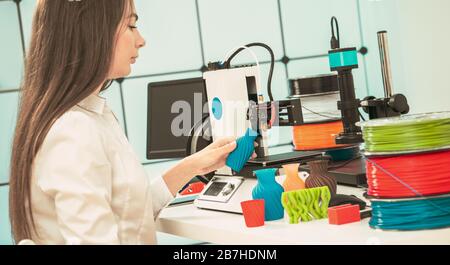 Young female designer works with a 3D printer in a design studio Stock Photo