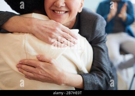 Close up of smiling female psychologist embracing African-American teenager during therapy session in support group, copy space Stock Photo