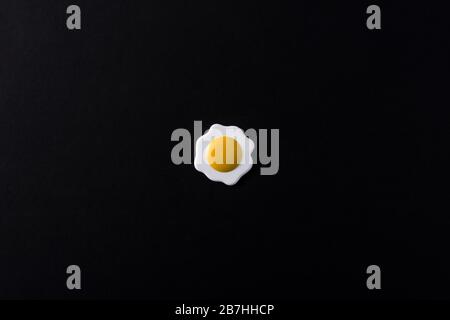 Minimalist fried egg on black background Stock Photo