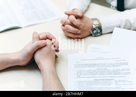 The clasped male hands of two businessmen. negotiations at the table, making a decision on hiring a job at a difficult interview, dialogue of opponents, debate, business confrontation, challenge concept, close up. Stock Photo