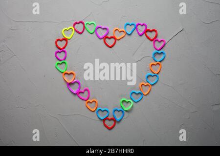 heart lined with colorful rubber bands for weaving on a concrete background Stock Photo