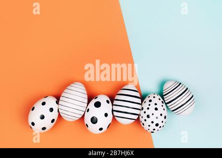 Easter eggs dotted on multicolored background. Festive concept. Flat lay style Stock Photo