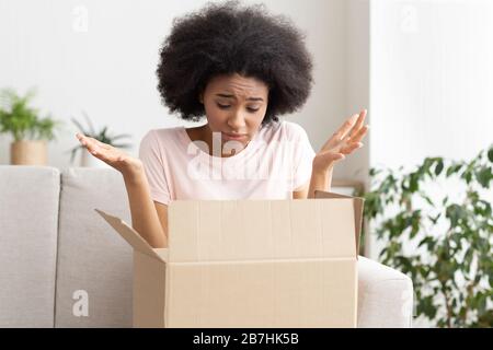 Disappointing online buying. Girl throws up hands Stock Photo