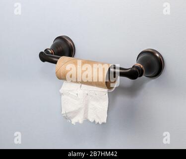 Empty roll of toilet paper in bathroom. Concept of supply and demand shortage, hoarding and stockpiling household goods Stock Photo