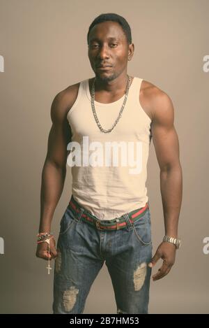 Studio shot of young handsome African man against gray background Stock Photo