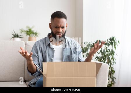 Man spreads his hands, having problem with bad shopping order Stock Photo