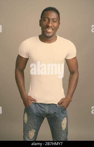 Studio shot of young handsome African man against gray background Stock Photo