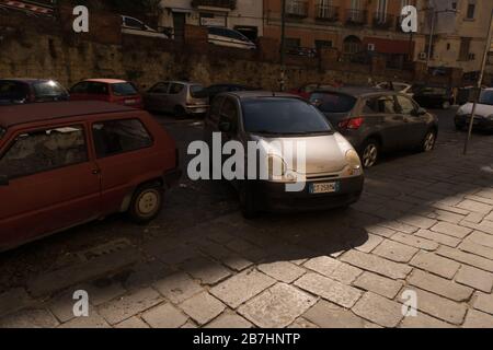 A badly parked car mounting the pavement in street of Naples Stock Photo