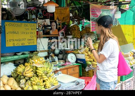 Thanon Khao San, Bangkok, Thailand - January 19, 2020 :  asian tourist woman looking and order mango sticky rice the famous traditional thai dessert f