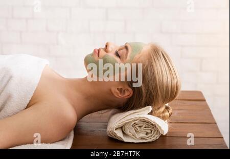 Millennial woman in spa salon with mask on face Stock Photo