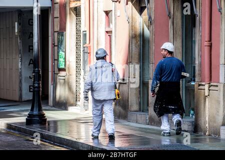 Gijon, Spain. 16th February, 2020. Two construction workers walk on the street on February 16, 2020 in Gijon, Spain, after Spanish government approved Spain’s state of alarm decree to confine the whole country and reduce coronavirus infections. Coronavirus COVID-19 infections in Spain increase 1.000 in a day to reach 9.190, with more than 300 deaths. ©David Gato/Alamy Live News Stock Photo