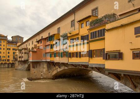 FLORENCE ITALY THE PONTE VECCHIO BRIDGE AND HOUSES OR SHOPS SPANNING THE RIVER ARNO IN FLOOD Stock Photo