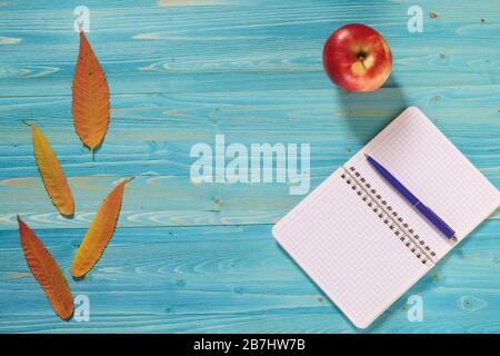 Notebook for records and autumn leaves on a wooden table. Lyrical mood Stock Photo