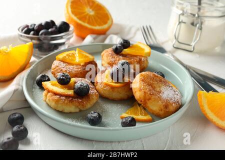 Breakfast of cheese pancakes on white background, close up