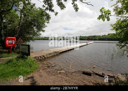 Aghinver cruiser tied up at wooden jetty on Lower Lough Erne,County Fermanagh, on a summer day beside Tully Castle in the Fermanagh Lakelands. Stock Photo