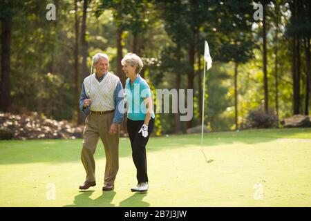 Older couple sharing a laugh on a golf course Stock Photo