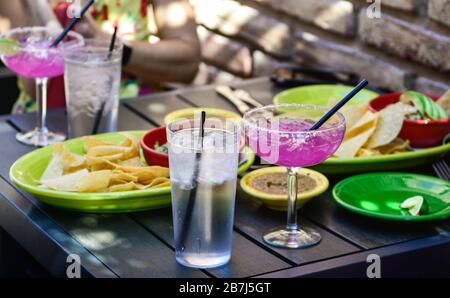 Rim salted, Hot pink cocktails accent the chips and salsa in colorful dishes on patio table at trendy Mexican restaurant in Scottsdale, AZ, Stock Photo