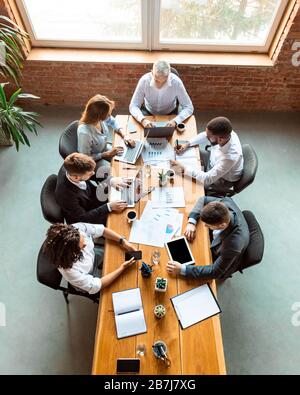 Diverse Coworkers Working Using Computers Sitting At Desk In Office Stock Photo