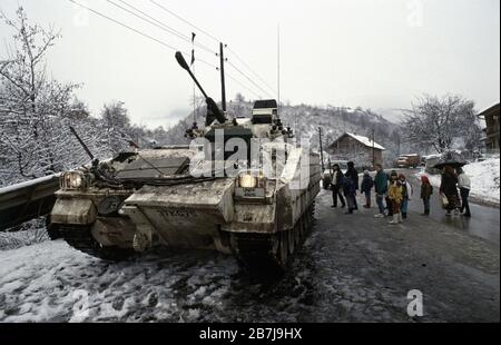 20th January 1994 During the war in central Bosnia: a group of local children stand next to a British Army Warrior of the Coldstream Guards on the roadside, immediately south of the Muslim village of Lisac. Stock Photo