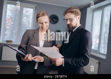 Business partners standing in office with documents Stock Photo
