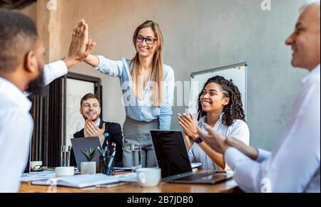 Coworkers Giving High-Five Celebrating Success At Work In Office, Panorama Stock Photo