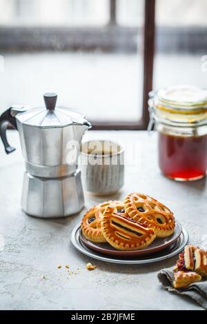 Homemade jam cookies with coffee on the kitchen table. Stock Photo