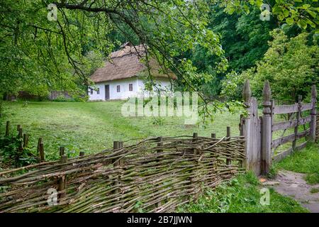 Ancient peasant Ukrainian house in the spring with a thatched roof in the old village of national architecture, Ukraine. Stock Photo