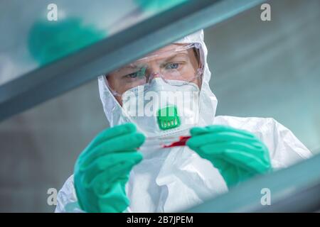 Virologist healthcare professional analyzing blood test sample in lab tubes, close up of medical worker working, selective focus