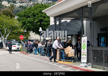 Line of shoppers wait outside a grocery store to prepare for corona virus outbreak Stock Photo