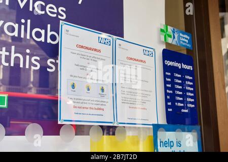 NHS Coronavirus public health information signs outside a Boots store in London Stock Photo