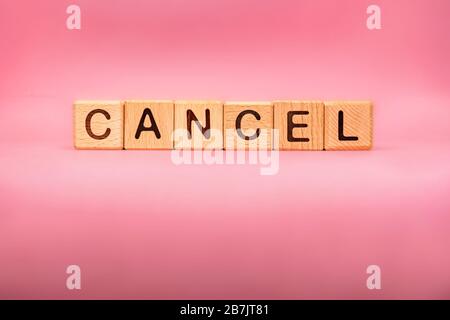 CANCEL word made with building blocks, business concept. Word CANCEL on pink background. Stock Photo