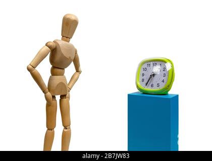 Isolated wooden human mannequin over a white background watching a green clock Stock Photo