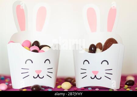 Rabbit treat box with sweet almond eggs and chocolate eggs. Easter candies and party ideias Stock Photo
