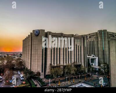 Beautiful and tall Standard bank buildings in Simmonds street Selby Johannesburg CBD area under a cloudy and sunset sky Stock Photo