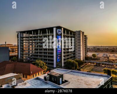 Beautiful and tall Standard bank buildings in Simmonds street Selby Johannesburg CBD area under a cloudy and sunset sky Stock Photo