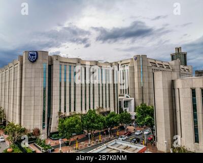 Beautiful and tall Standard bank buildings in Simmonds street Selby Johannesburg CBD area under a cloudy and sunset sky Stock Photo