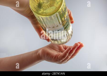 Little girl disinfecting hands with cologne. Turkish Lemon cologne with 80 degree alcohol for disinfection and killing the viruses on your hands. Stock Photo