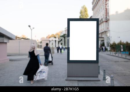 Empty rectangular bilboard. Photographed on the edge. Walking people. Stock Photo