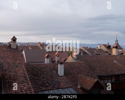 View of rooftops with beautiful roof tiles in the old medieval city of Murten or Morat in Switzerland at dusk. Stock Photo