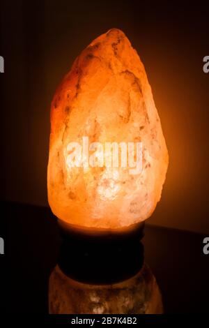 Himalayan Salt lamp on black background close up Stock Photo