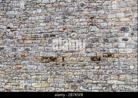 Flat stone wall background, made from irregular sized stone blocks at Eastern State Penitentiary, Philadelphia, Pennsylvania background, wallpaper Stock Photo