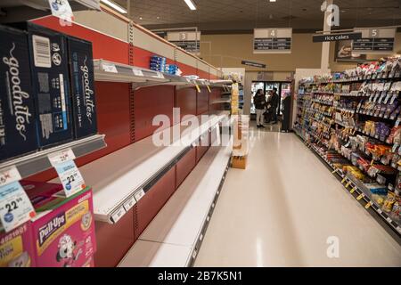 NORTH VANCOUVER, BC, CANADA - MAR 15, 2020: Shelf at a supermarket mostly empty with only a few packages of toilet paper left amid panic buying as the Stock Photo