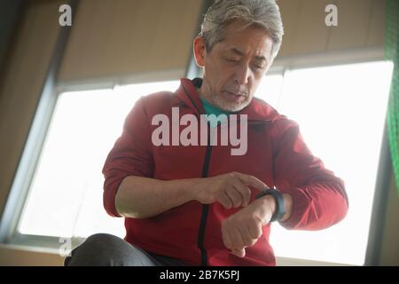 Senior man using smart watch on his wrist Stock Photo