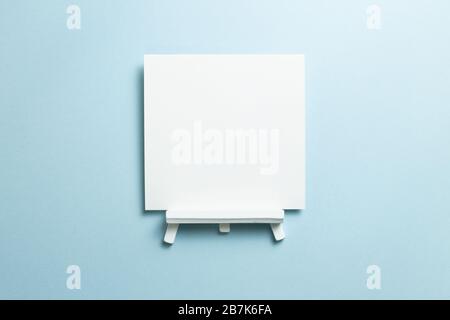 White easel with blank canvas isolated on blue background. top view, copy space Stock Photo