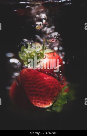 Blured starberrys falling into water, bubbles, isolated Stock Photo